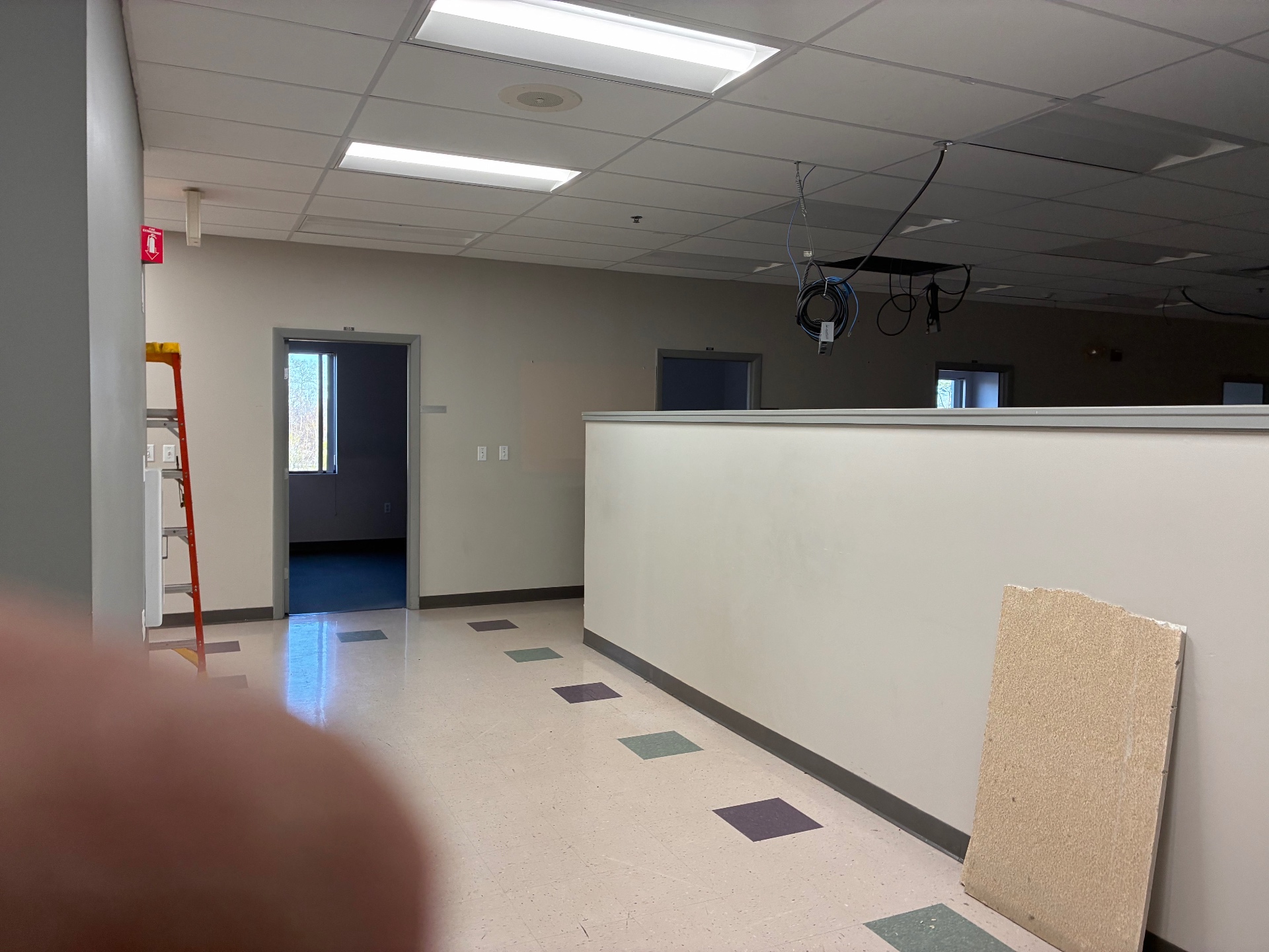 Before build-out photo of an unfinished hallway and partition area