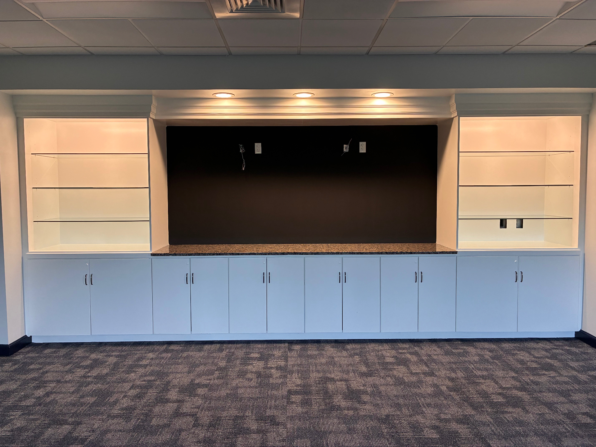 After fit-out photo of a completed commercial room with finished cabinetry and trim